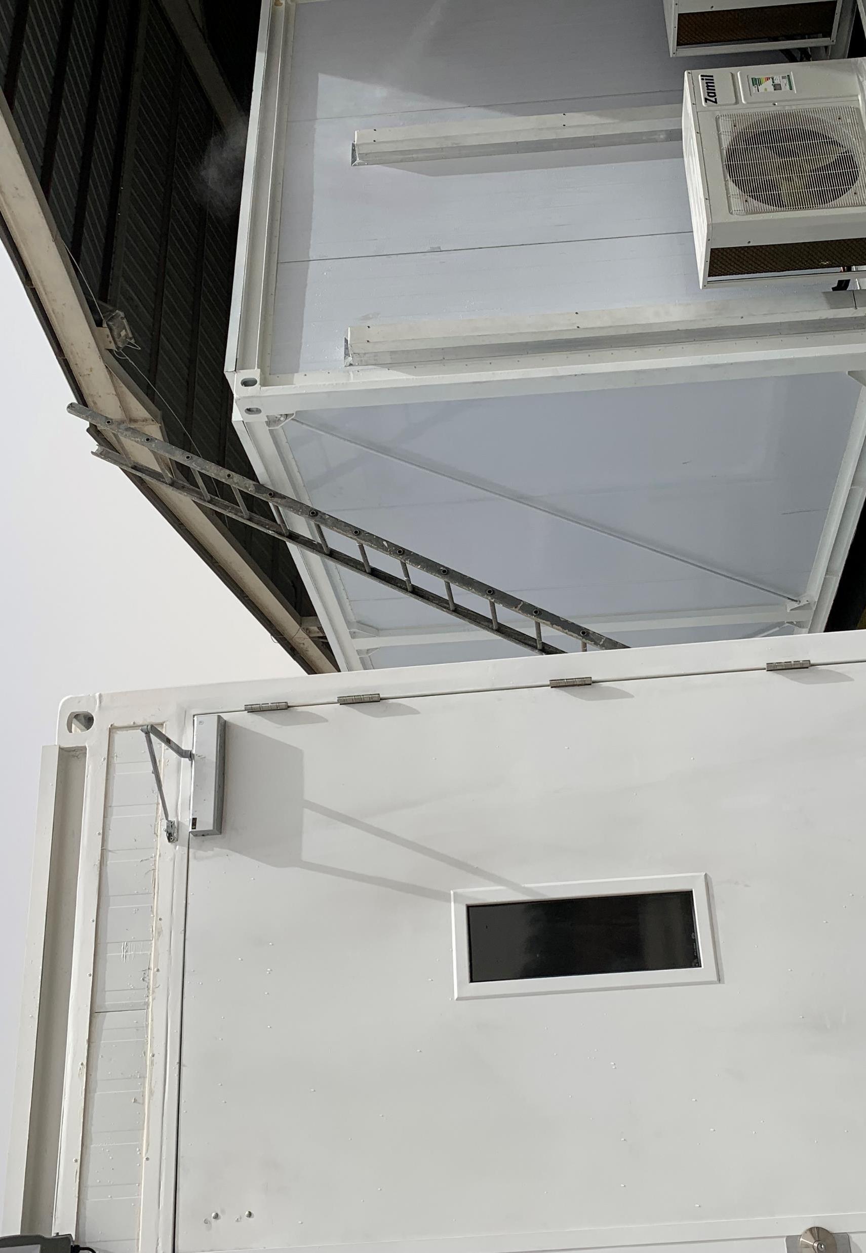 White site cabin with an external air conditioner